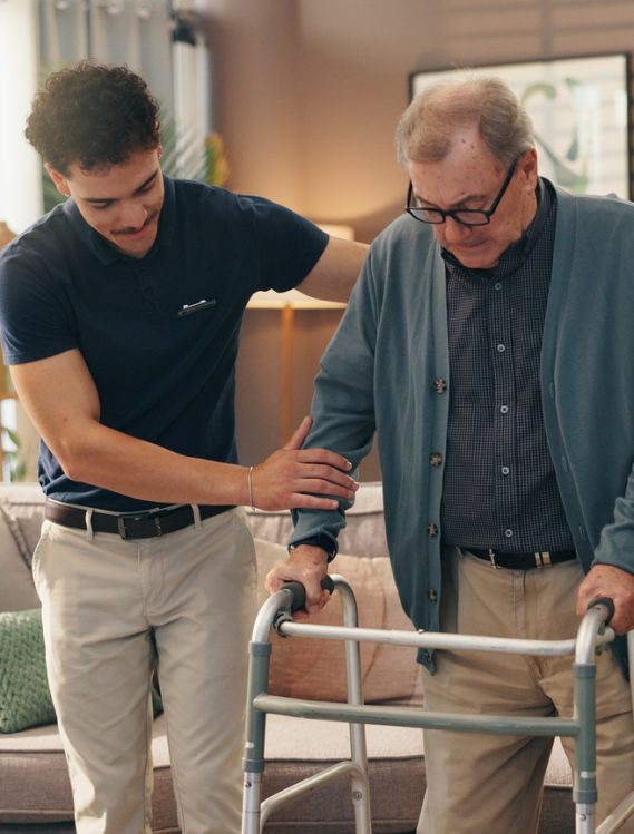 Old man, caregiver and help with walker in home for mobility support, assistance or rehabilitation. Health worker, senior person and walking guide in assisted living facility for balance and recovery